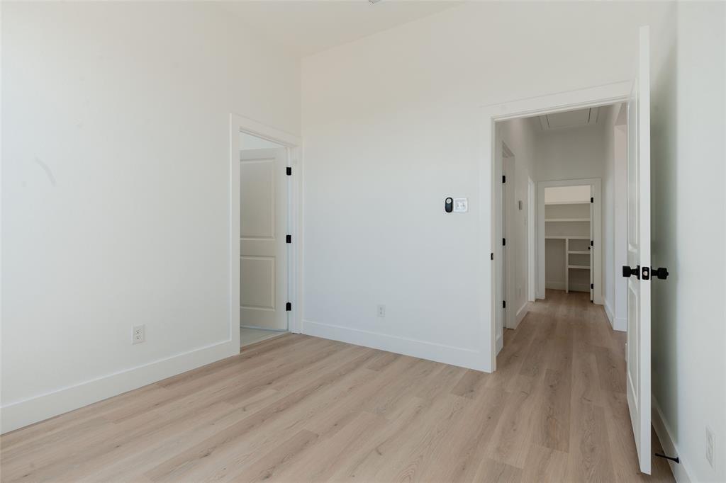 592 Highview Court Godley, TX 76044 - Photo 13 of 21 Secondary bedroom with light wood-style flooring and a walk in closet