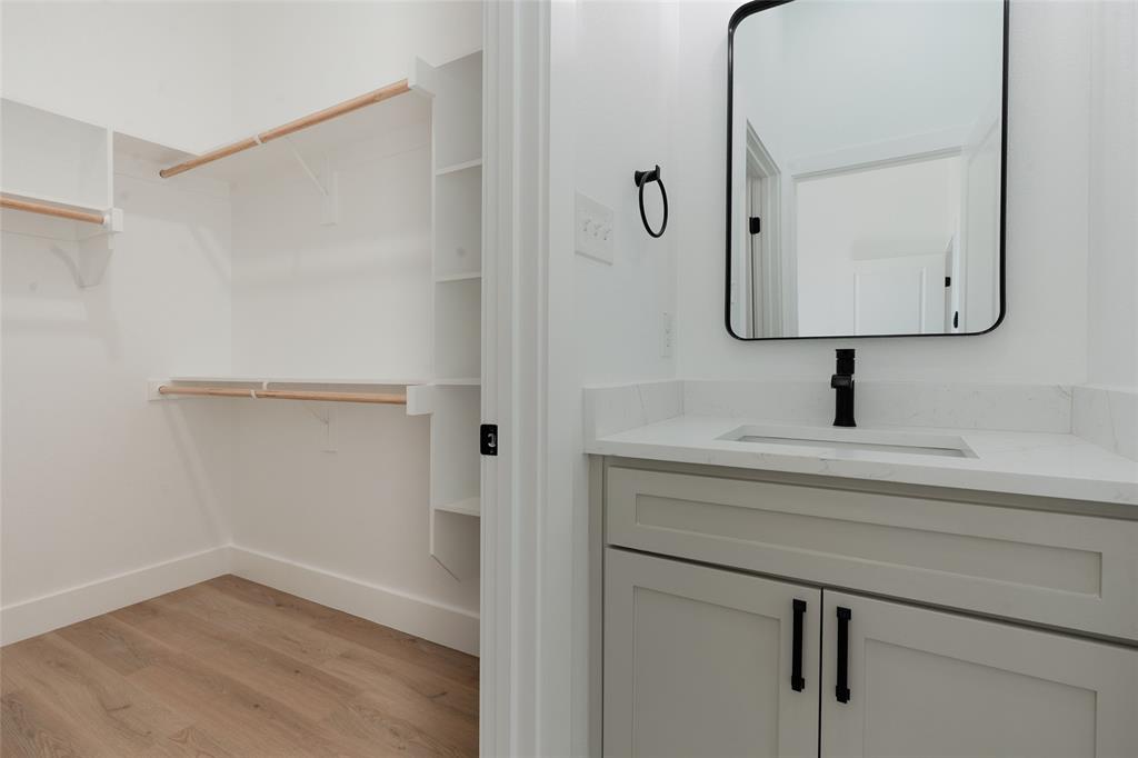 592 Highview Court Godley, TX 76044 - Photo 14 of 21 Bathroom with a spacious closet, vanity, and light wood-style floors
