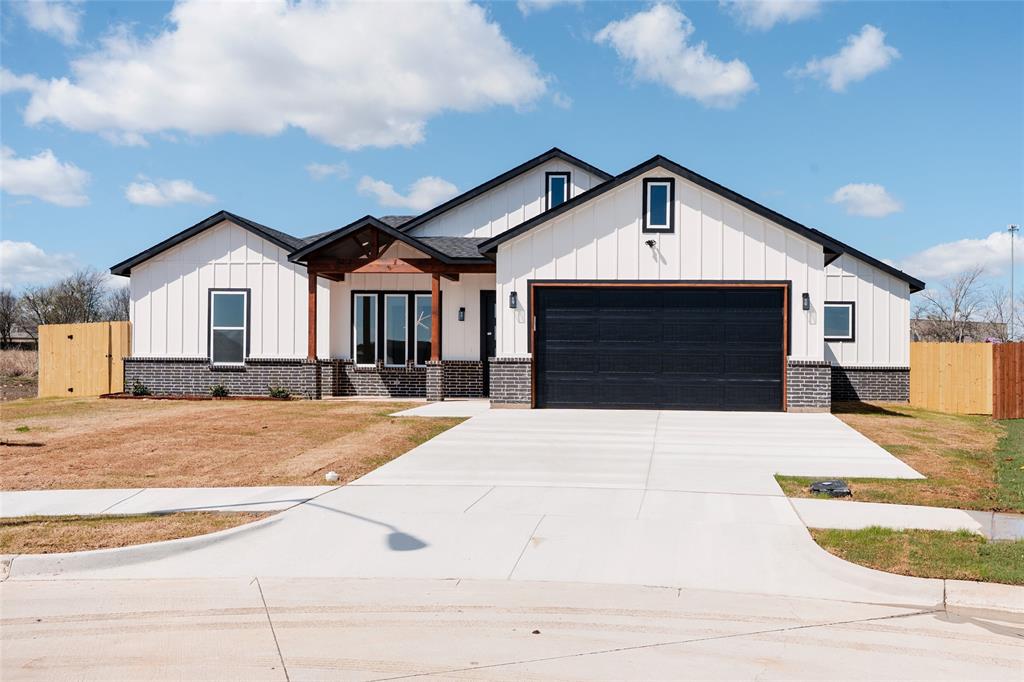 592 Highview Court Godley, TX 76044 - Photo 20 of 21 Modern farmhouse with board and batten siding, a garage, concrete driveway, and covered porch