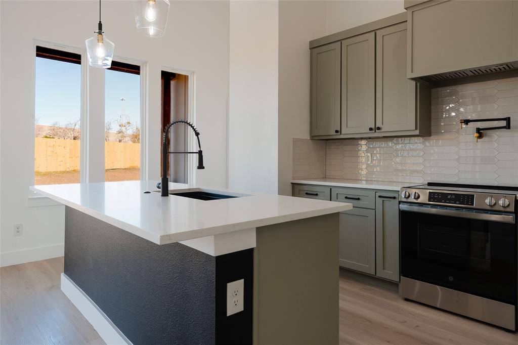 592 Highview Court Godley, TX 76044 - Photo 4 of 21 Beautiful kitchen with custom cabinetry, decorative lighting, and island seating.