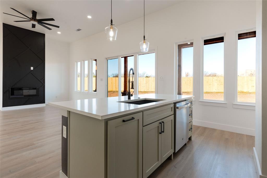 592 Highview Court Godley, TX 76044 - Photo 21 of 21 Kitchen with a center island with sink, open floor plan, light wood-style floors, pendant lighting, and dishwasher