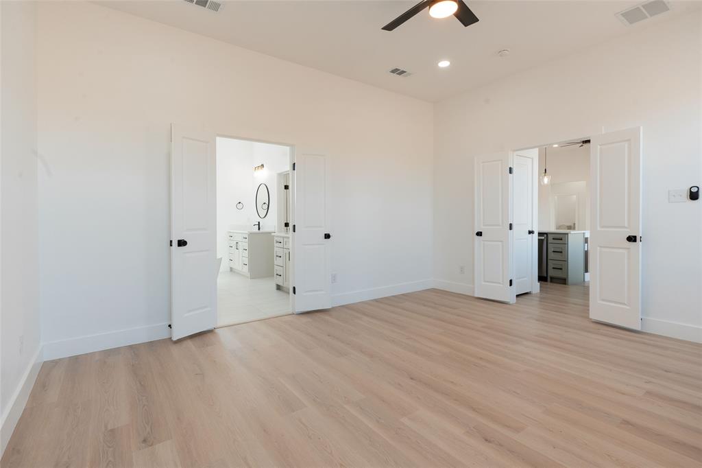 592 Highview Court Godley, TX 76044 - Photo 8 of 21 Spacious primary bedroom featuring an ensuite bathroom, light wood-style flooring, ceiling fan, and recessed lighting