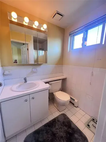 a bathroom with a sink a toilet and mirror