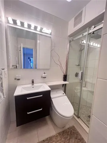 a bathroom with a toilet a sink and glass door
