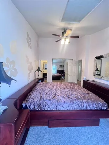 a bedroom with a large bed and a chandelier