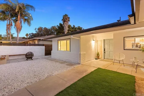 a view of an house with backyard space and palm tree