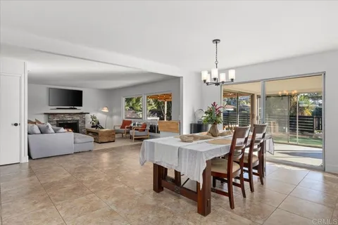 a kitchen with stainless steel appliances kitchen island a table chairs sink and cabinets