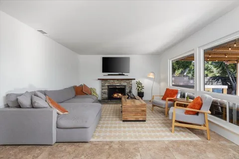 a kitchen with a sink dishwasher and white cabinets with wooden floor