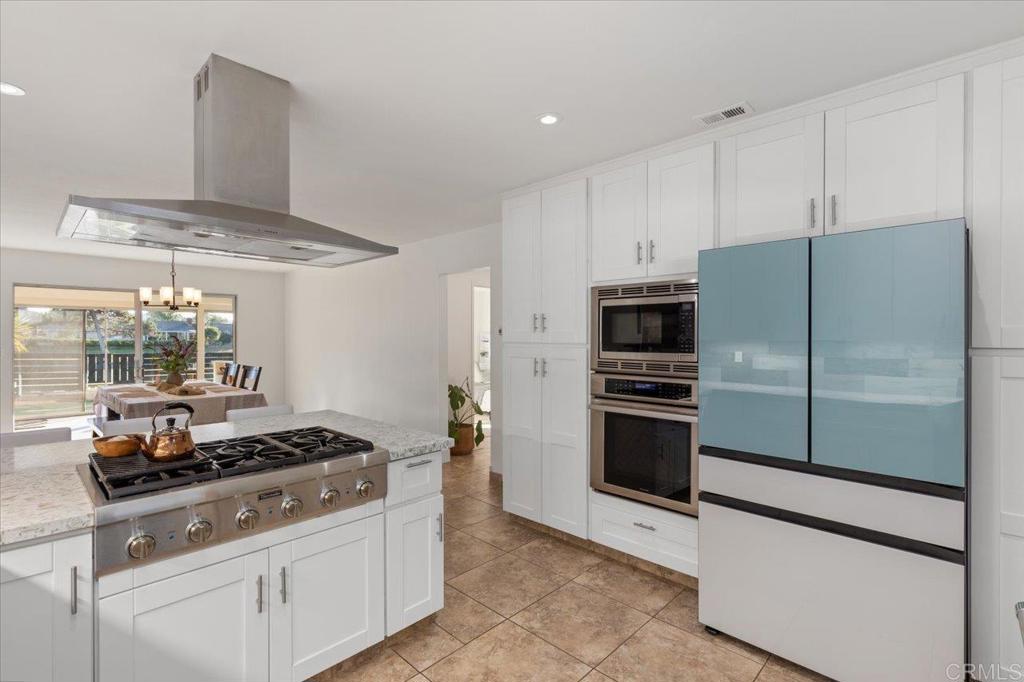 1267 Discovery Street San Marcos, CA 92078 - Photo 29 of 75 a kitchen with stainless steel appliances granite countertop a stove and a refrigerator