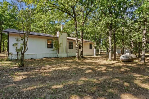 a backyard of a house with barbeque oven table and chairs