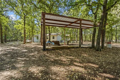 a backyard of a house with barbeque oven table and chairs