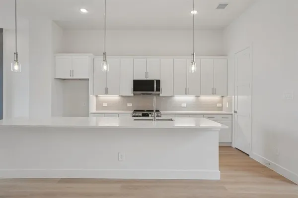 a kitchen with kitchen island a sink stainless steel appliances and cabinets