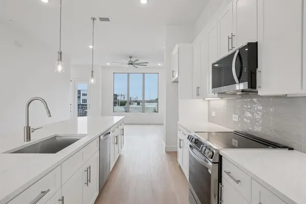 a kitchen with kitchen island a sink stainless steel appliances and a counter top