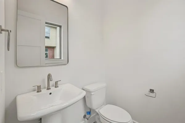 a kitchen with a sink dishwasher and white cabinets with wooden floor