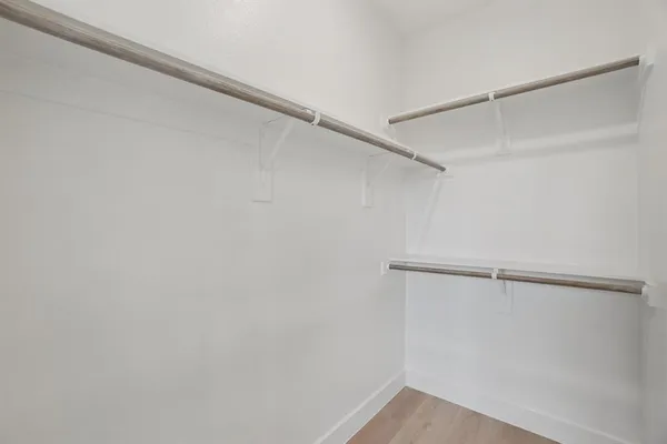 an empty room with a window and ceiling fan