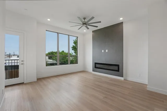 a view of a livingroom with wooden floor a ceiling fan and a window