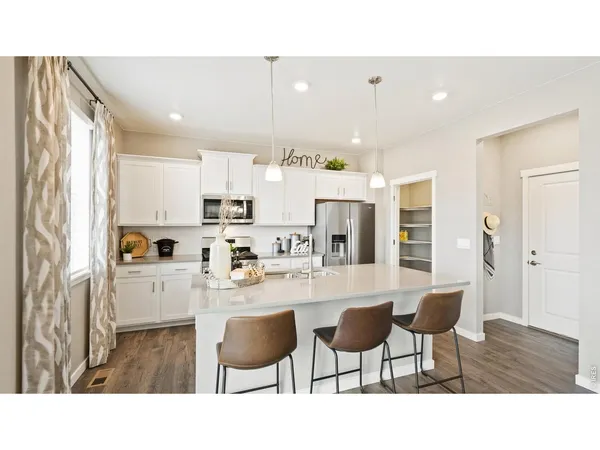 a kitchen with cabinets and wooden floor