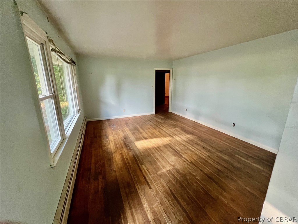 1642 Regent Road Topping, VA 23169 - Photo 6 of 10 Empty room featuring baseboard heating and dark hardwood / wood-style flooring