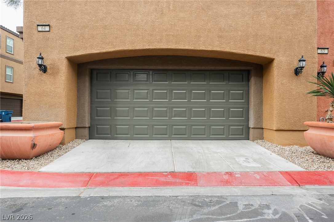 4650 Ranch House Road, Unit 64 North Las Vegas, NV 89031 - Photo 8 of 39 This residence features a paneled garage door and a sturdy concrete driveway, ensuring practical access and durability.