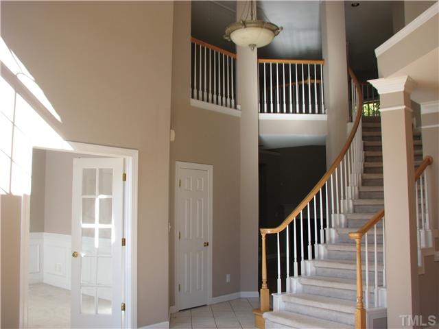 5029 Bartons Enclave Lane Raleigh, NC 27613 - Photo 3 of 25 a view of staircase with railing and a chandelier