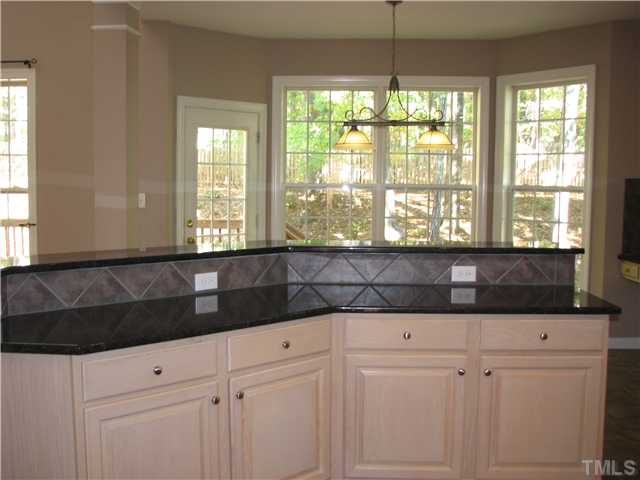 5029 Bartons Enclave Lane Raleigh, NC 27613 - Photo 8 of 25 a bathroom with a granite countertop sink a window and a shower