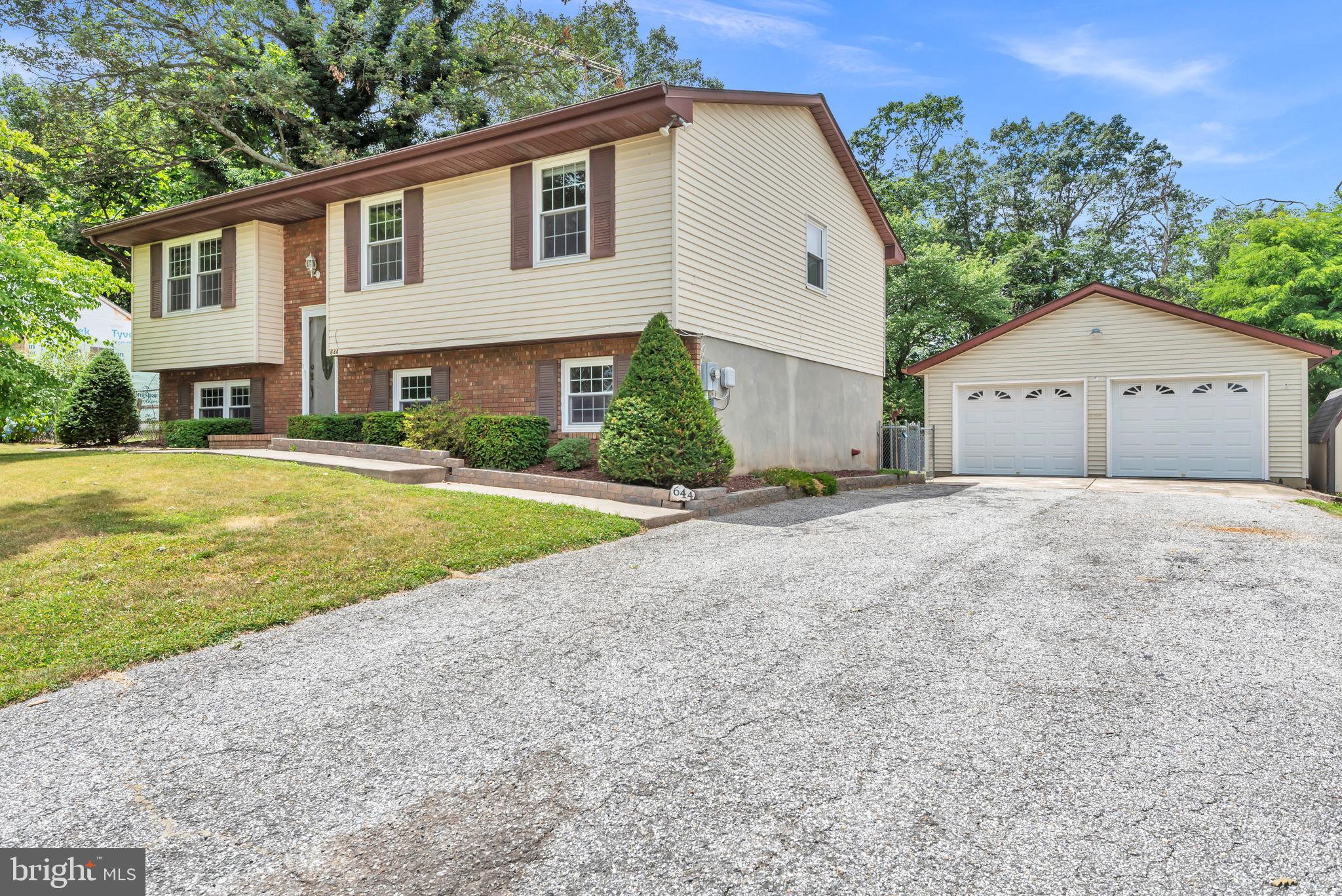 a view of a house with a yard and large tree