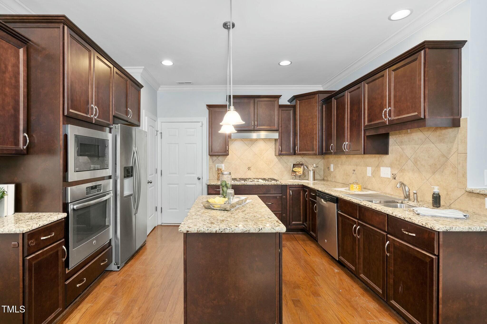 1052 Monmouth Loop Cary, NC 27513 - Photo 11 of 37 a kitchen with stainless steel appliances granite countertop a sink stove and refrigerator