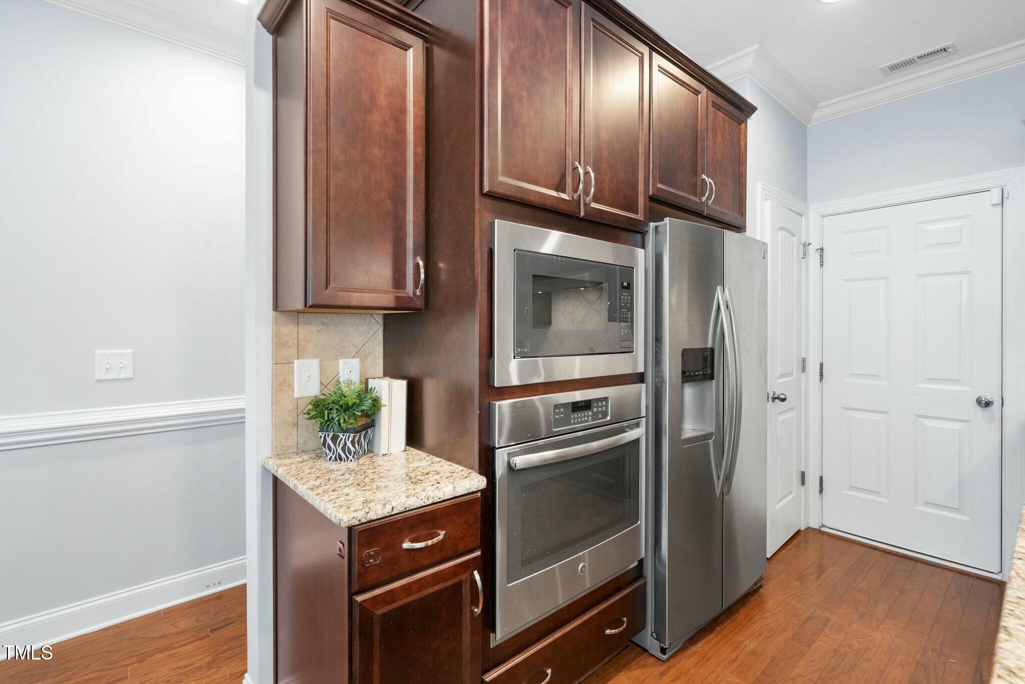 1052 Monmouth Loop Cary, NC 27513 - Photo 12 of 37 a kitchen with granite countertop stainless steel appliances and wooden cabinets