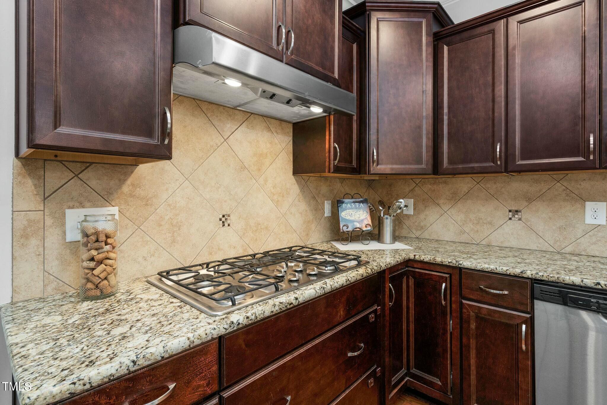 1052 Monmouth Loop Cary, NC 27513 - Photo 13 of 37 a kitchen with granite countertop a sink stainless steel appliances and cabinets