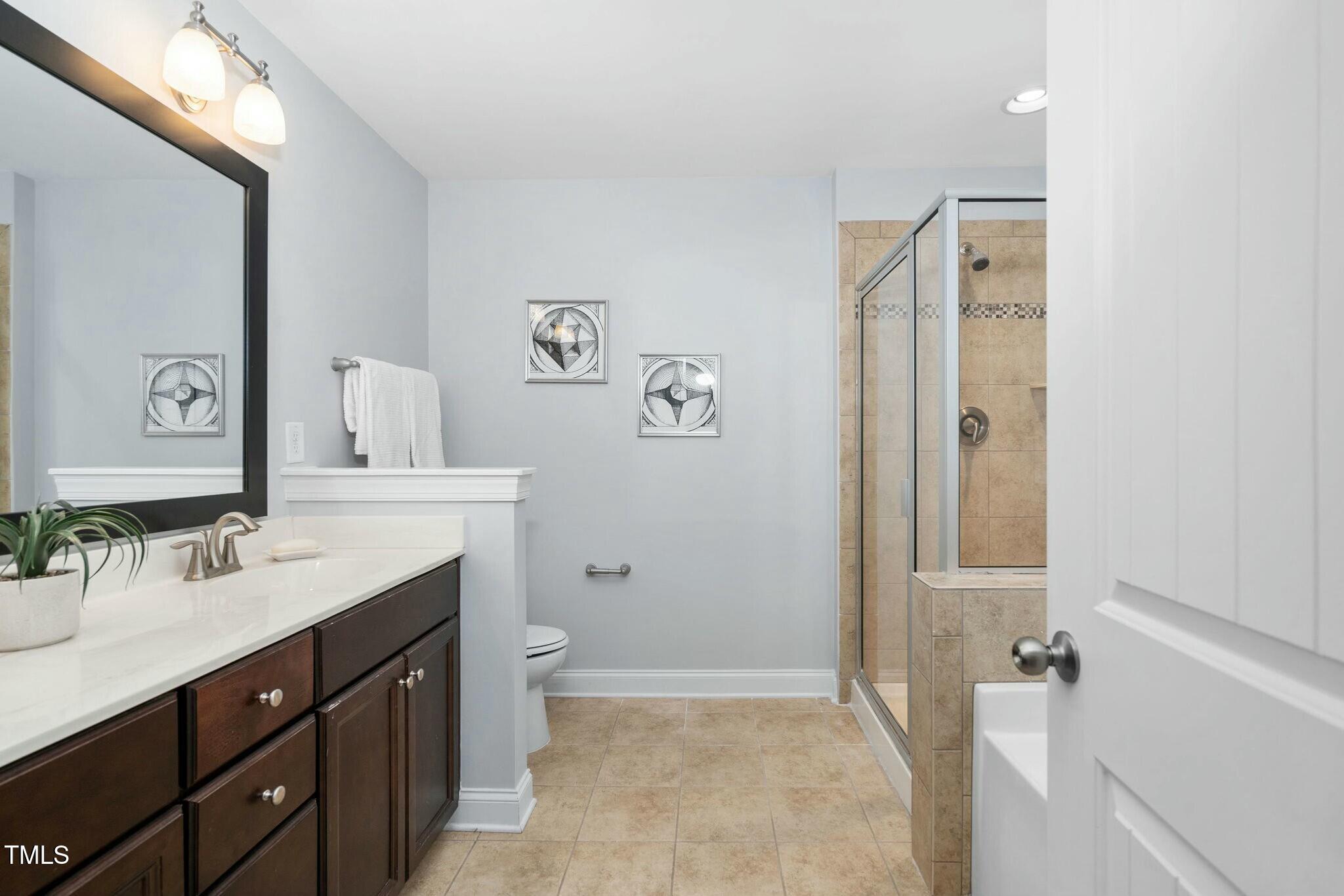 1052 Monmouth Loop Cary, NC 27513 - Photo 22 of 37 a bathroom with a sink a toilet and shower