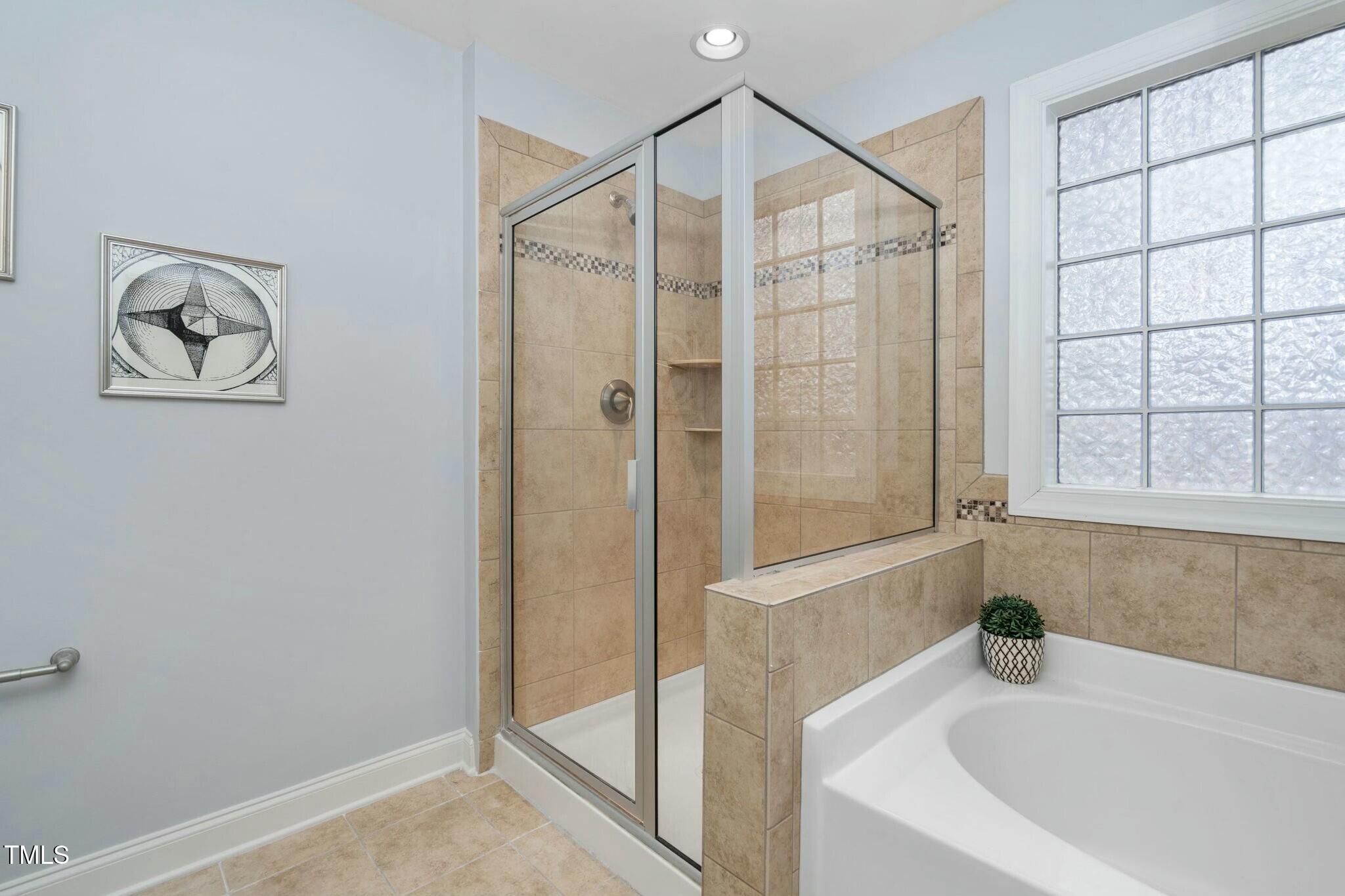 1052 Monmouth Loop Cary, NC 27513 - Photo 24 of 37 a bathroom with a bathtub and a shower