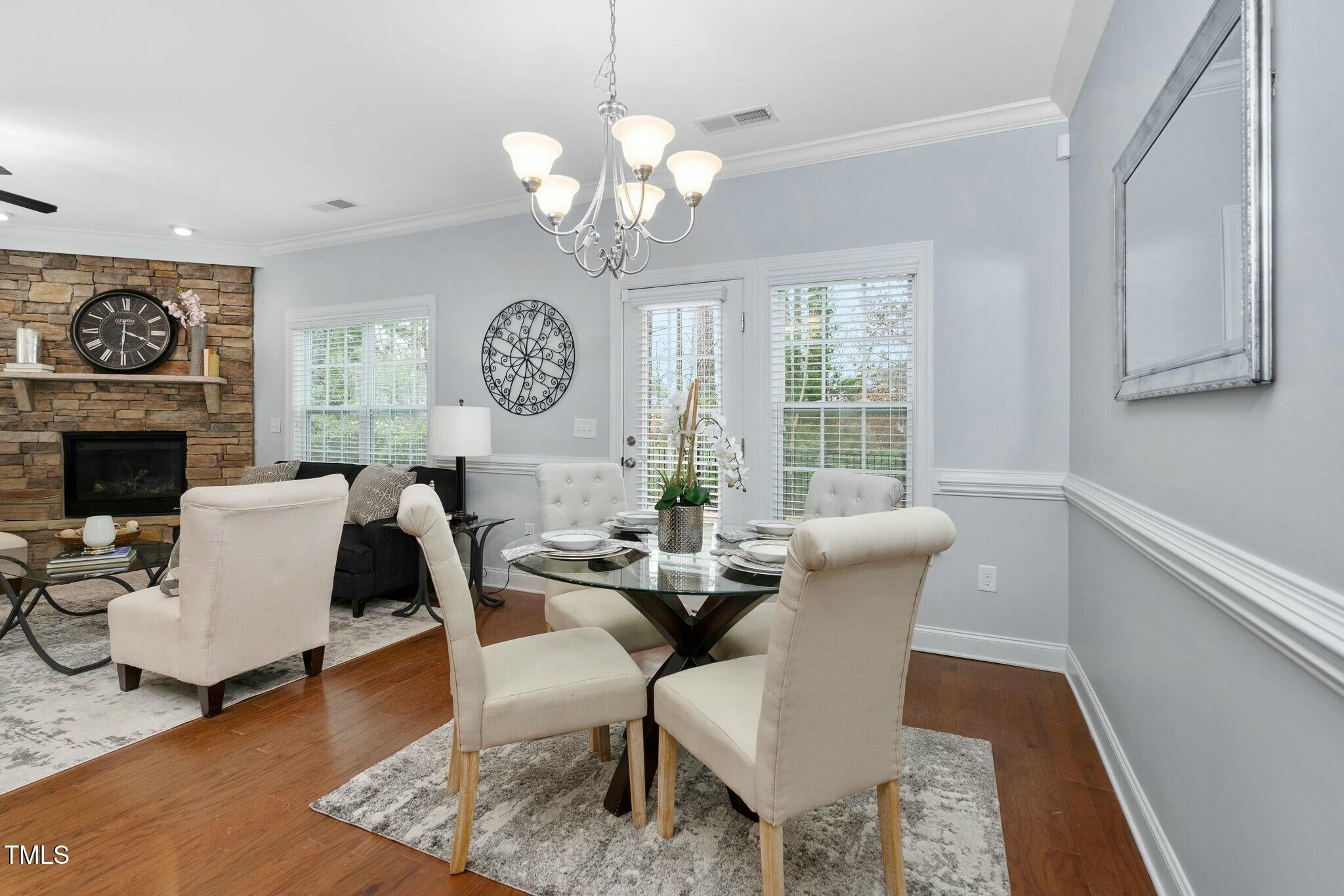 1052 Monmouth Loop Cary, NC 27513 - Photo 7 of 37 a view of a dining room with furniture a chandelier and wooden floor