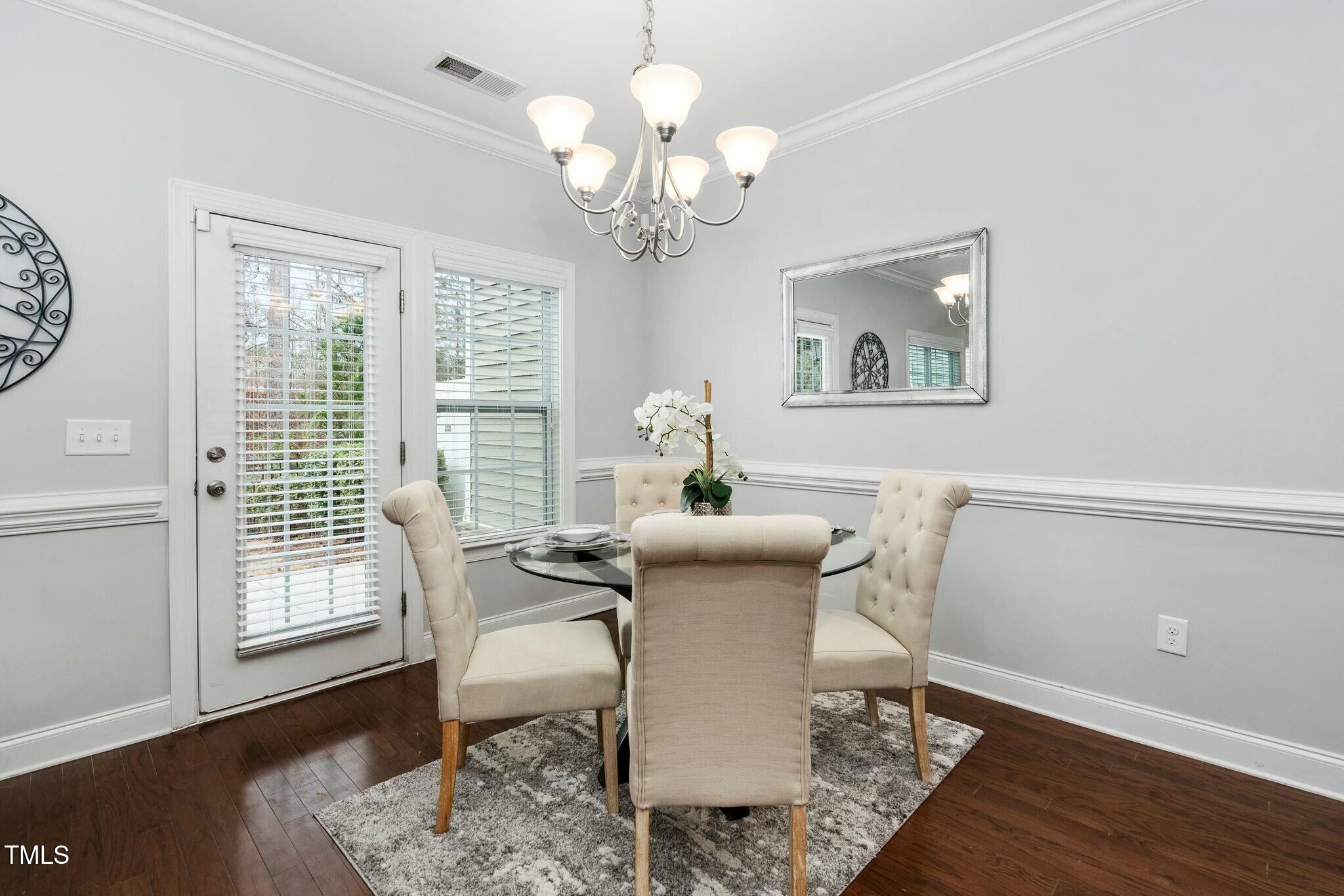 1052 Monmouth Loop Cary, NC 27513 - Photo 8 of 37 a dining room with wooden floor and a chandelier