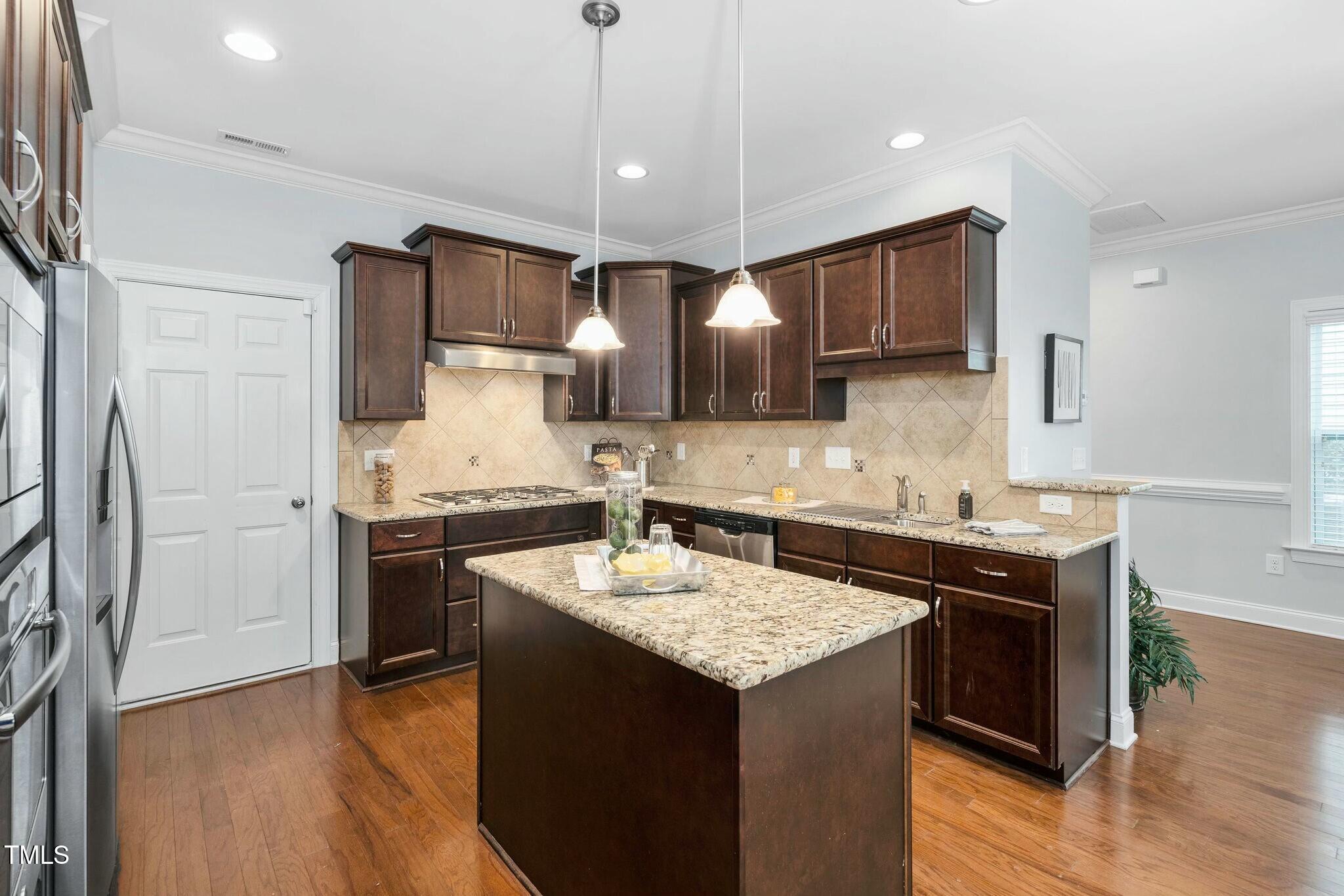 1052 Monmouth Loop Cary, NC 27513 - Photo 10 of 37 a kitchen with stainless steel appliances granite countertop a sink stove and refrigerator