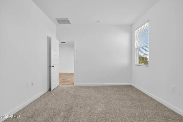 an empty room with windows and closet