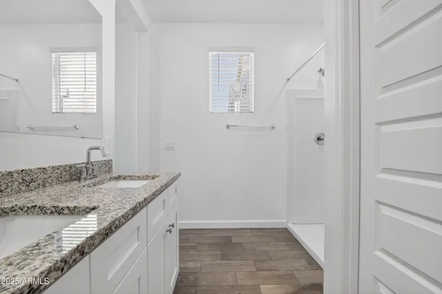 a bathroom with a granite countertop sink and a mirror