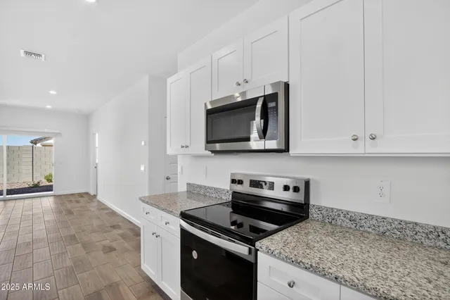 a kitchen with granite countertop a stove and a microwave