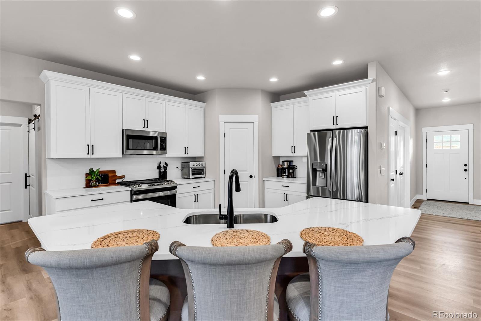 425 Miners Road Canon City, CO 81212 - Photo 13 of 33 a kitchen with stainless steel appliances kitchen island granite countertop a sink a stove a dining table and chairs