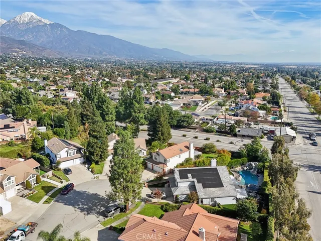 an aerial view of a city with lots of residential buildings and mountain view in back