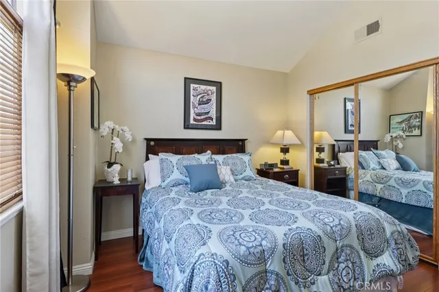 a bedroom with a bed and wooden floor