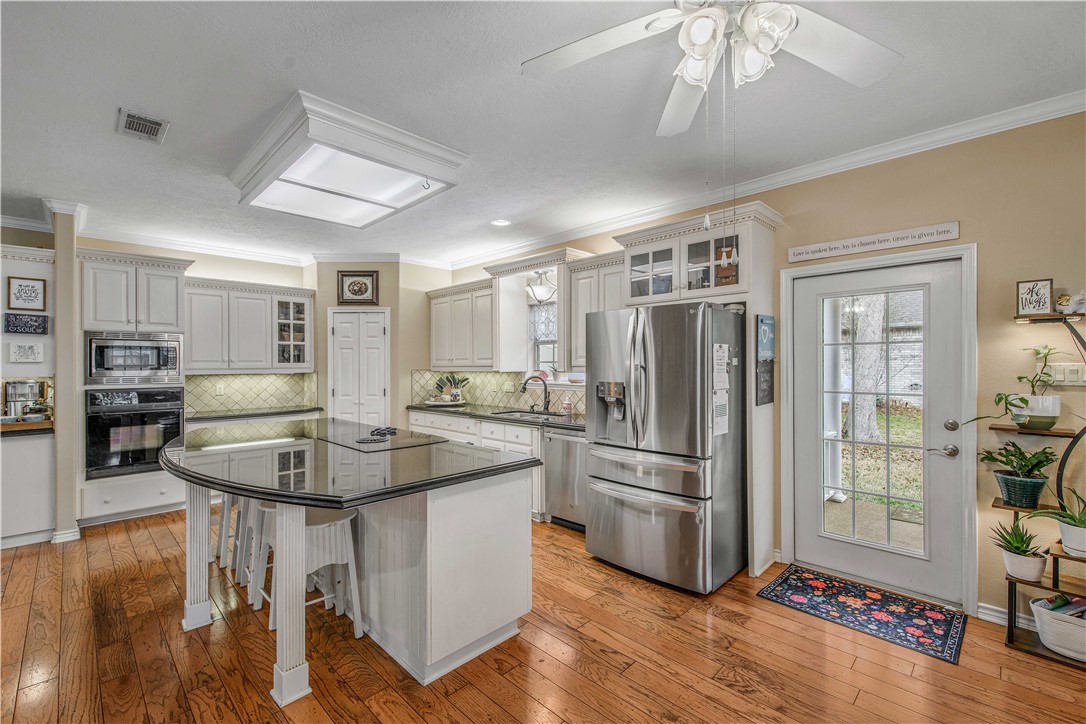 7 Hickory Ridge Lane Hilltop Lakes, TX 77871 - Photo 15 of 37 a kitchen with stainless steel appliances granite countertop a refrigerator a stove a sink a dining table and chairs