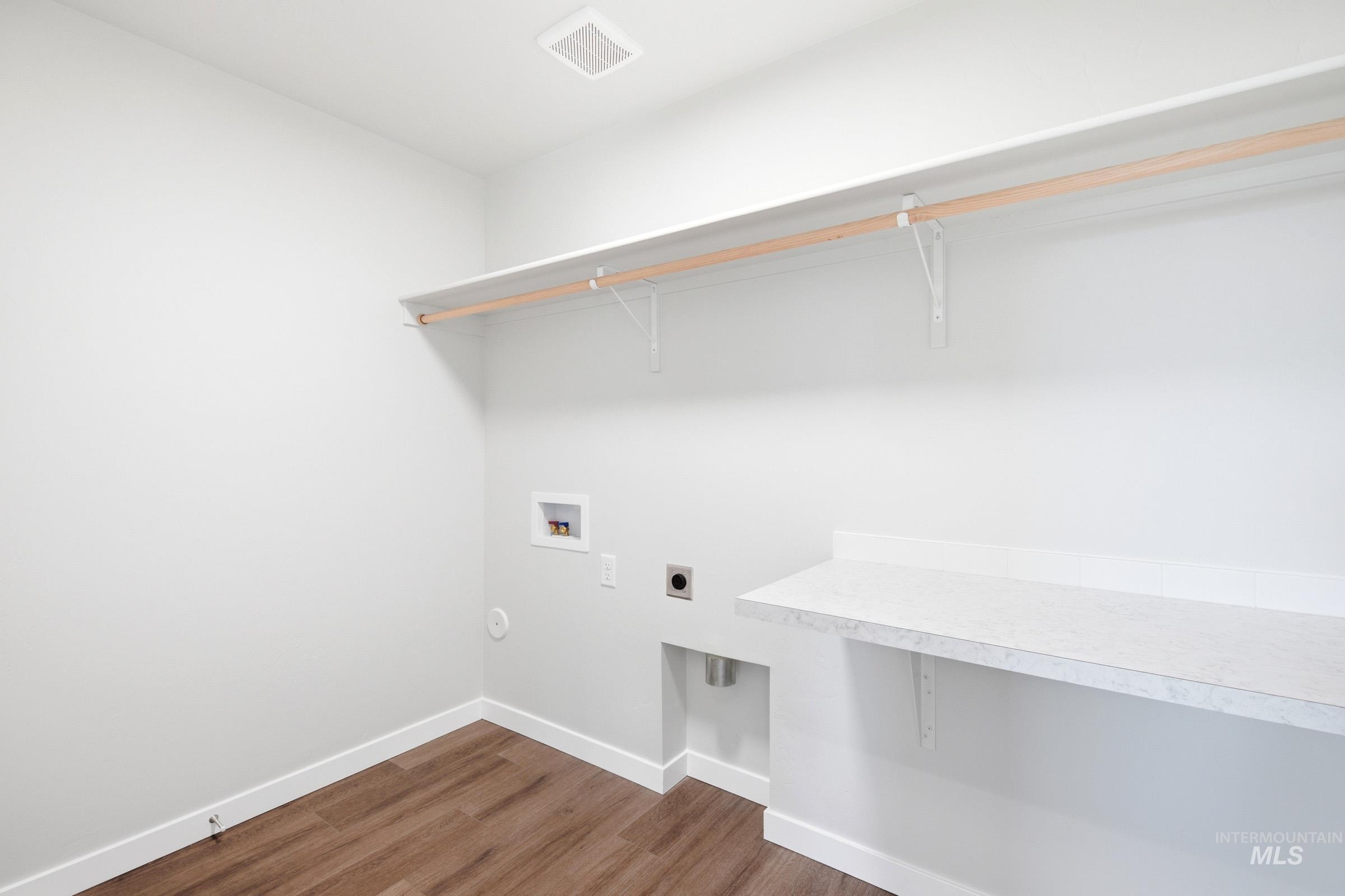 12877 Decatur Street Nampa, ID 83651 - Photo 19 of 22 Dedicated laundry area featuring wood-finish flooring, light neutral wall paint, and a built-in countertop with shelving