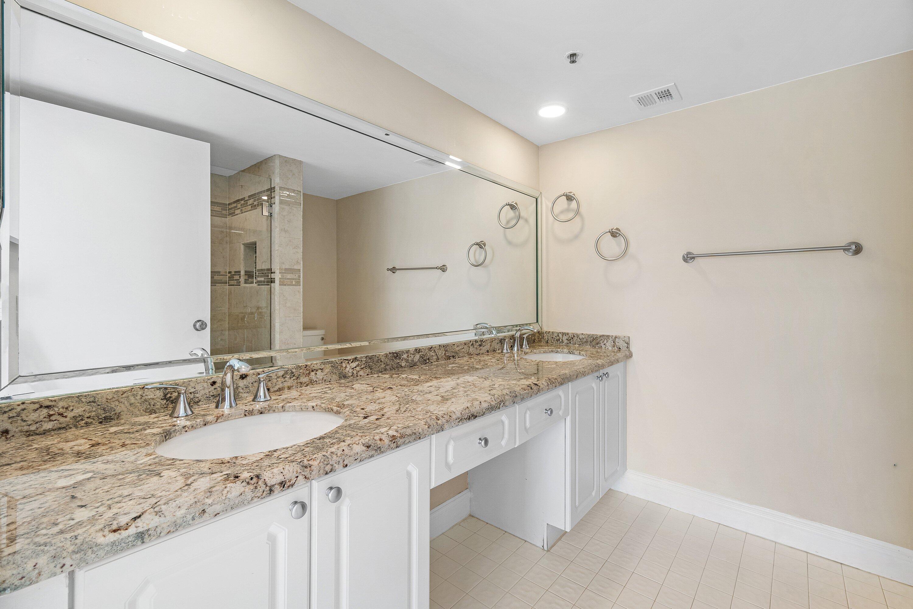14096 Huntington Pointe Drive, Unit 106 Delray Beach, FL 33484 - Photo 39 of 47 a bathroom with a granite countertop sink and a mirror