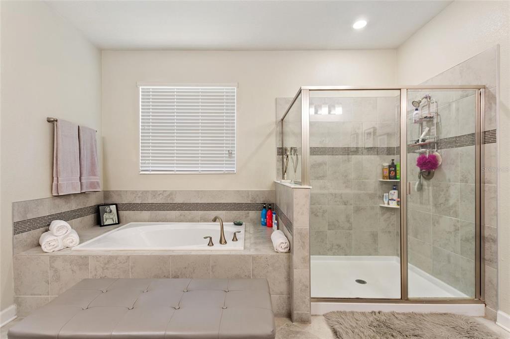 8811 Bally Neal Loop Davenport, FL 33896 - Photo 24 of 82 a bathroom with a tub and a shower