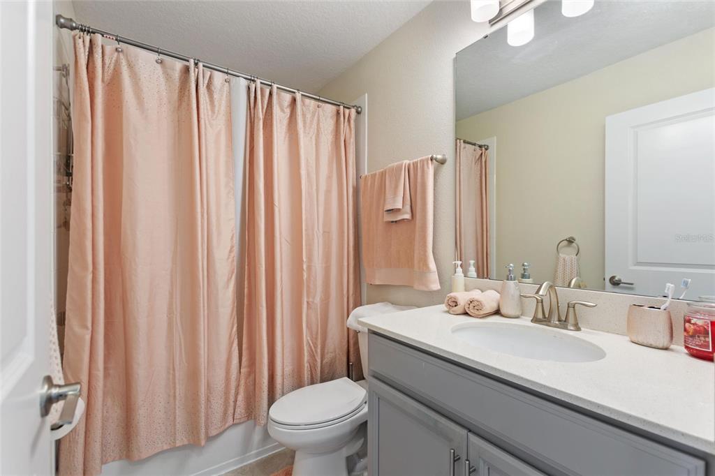 8811 Bally Neal Loop Davenport, FL 33896 - Photo 31 of 82 a bathroom with a sink a toilet and shower curtain