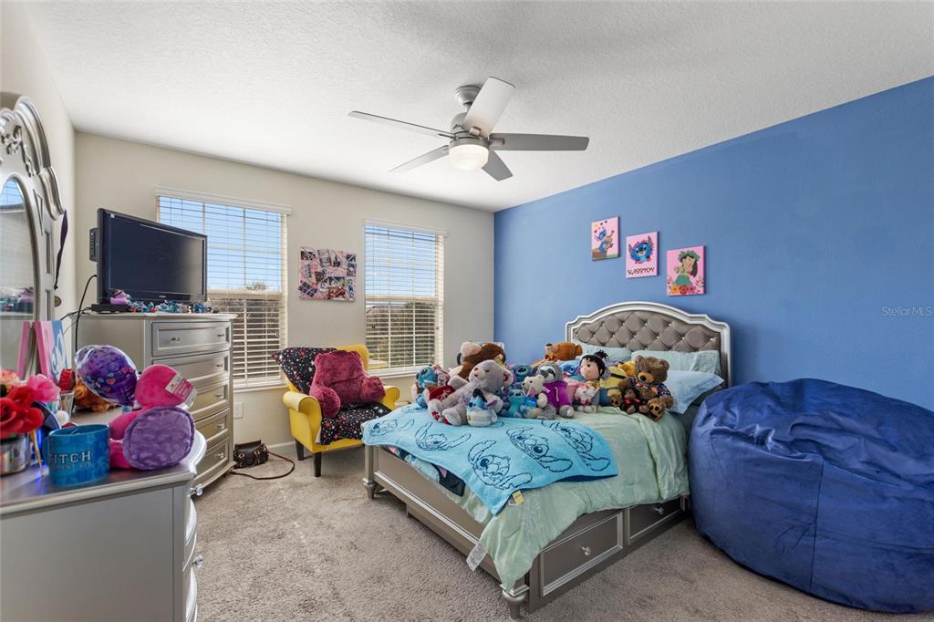 8811 Bally Neal Loop Davenport, FL 33896 - Photo 32 of 82 a bedroom with bed and a flat screen tv