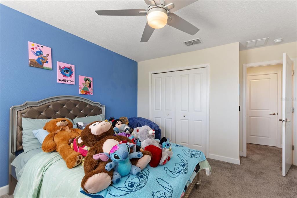 8811 Bally Neal Loop Davenport, FL 33896 - Photo 33 of 82 a bedroom with a bed and a chandelier