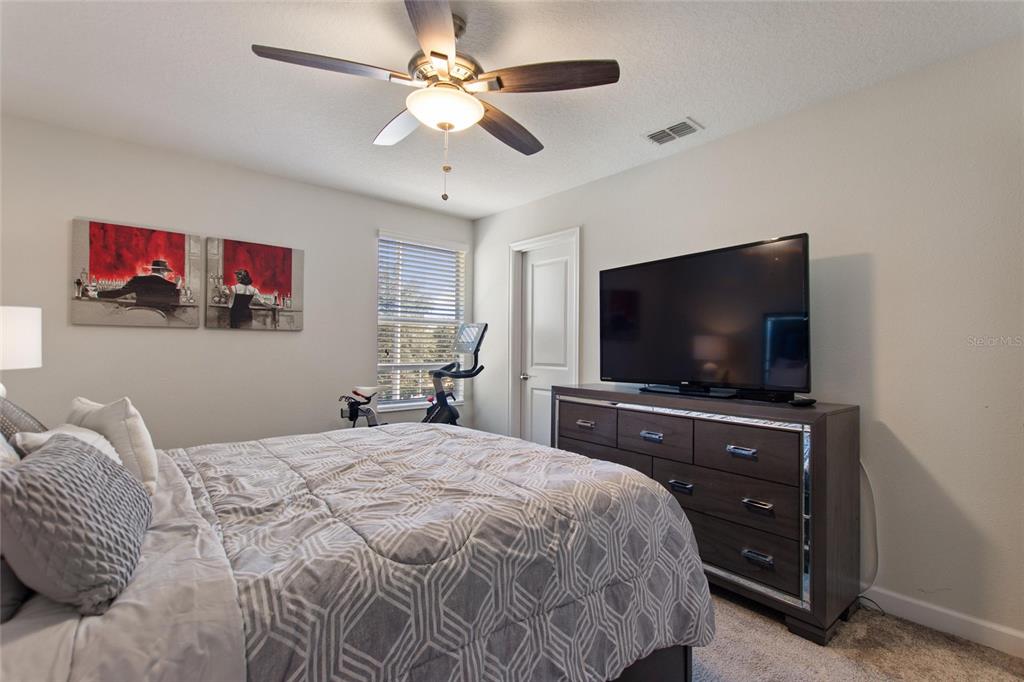 8811 Bally Neal Loop Davenport, FL 33896 - Photo 39 of 82 a bedroom with a bed and a flat screen tv