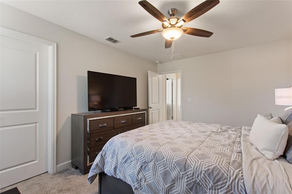 8811 Bally Neal Loop Davenport, FL 33896 - Photo 40 of 82 a bedroom with a bed and a flat screen tv