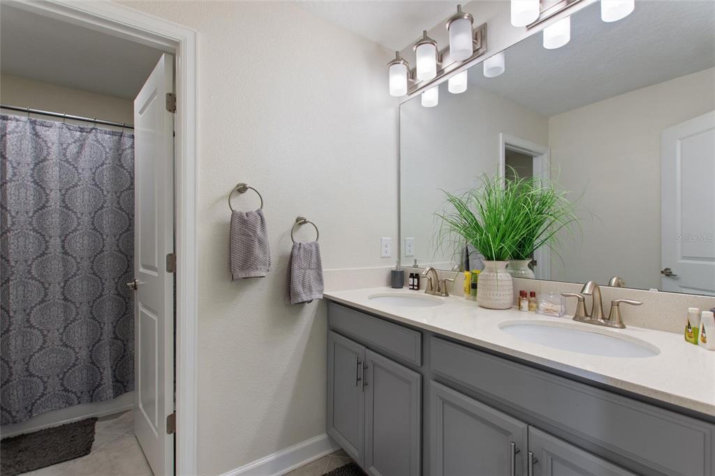 8811 Bally Neal Loop Davenport, FL 33896 - Photo 41 of 82 a bathroom with a sink a faucet a light fixture and a mirror